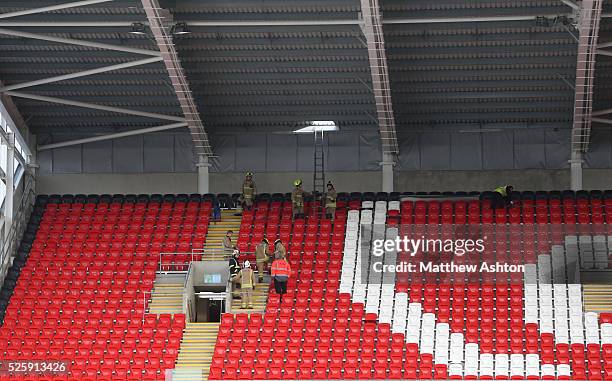 Firefighters and steward remove storm damage to the Ninian Stand at The Cardiff City Stadium home of Cardiff City Football Clubs ground