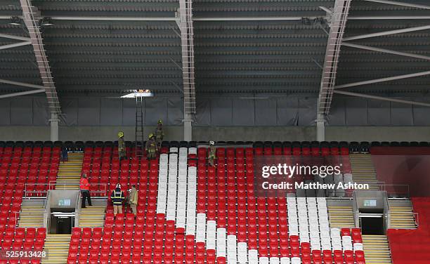 Firefighters and steward remove storm damage to the Ninian Stand at The Cardiff City Stadium home of Cardiff City Football Clubs ground