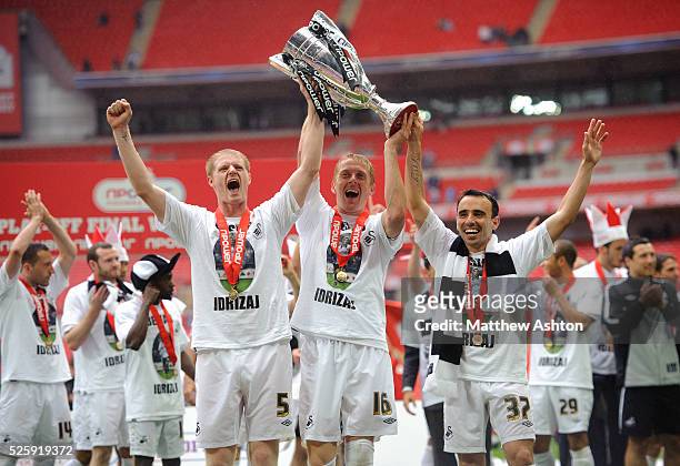 Alan Tate, Garry Monk and Leon Britton of Swansea City celebrate with the nPower Football League Championship trophy and promotion to the Premier...