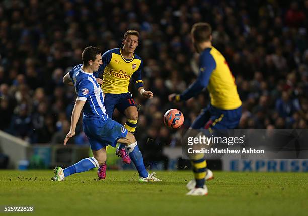 Mesut Ozil of Arsenal passes past Lewis Dunk of Brighton & Hove Albion to Aaron Ramsey of Arsenal