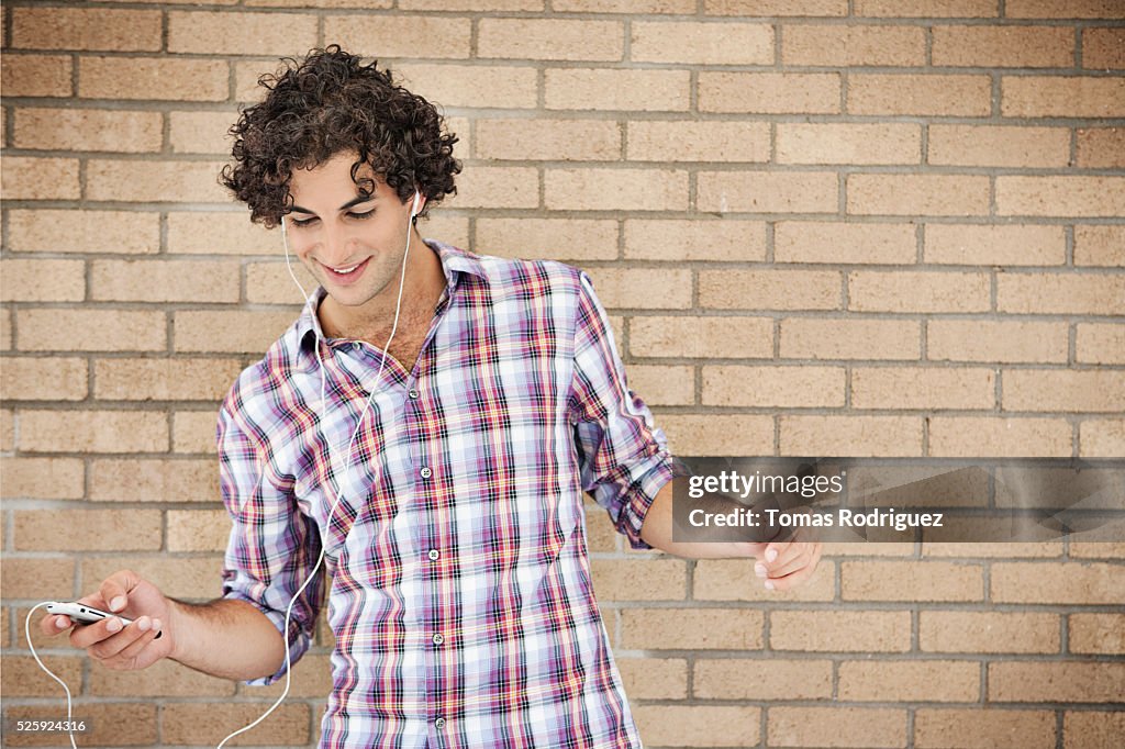 Portrait of smiling young man listening music