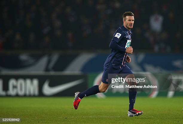 David Beckham of Paris Saint-Germain wearing Adidas boots runs past a PSG Nike sign