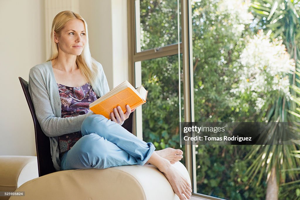 Woman reading book at home