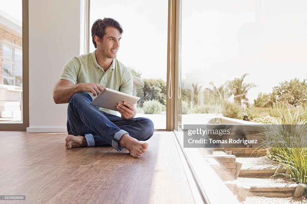 Man sitting on floor using tablet pc