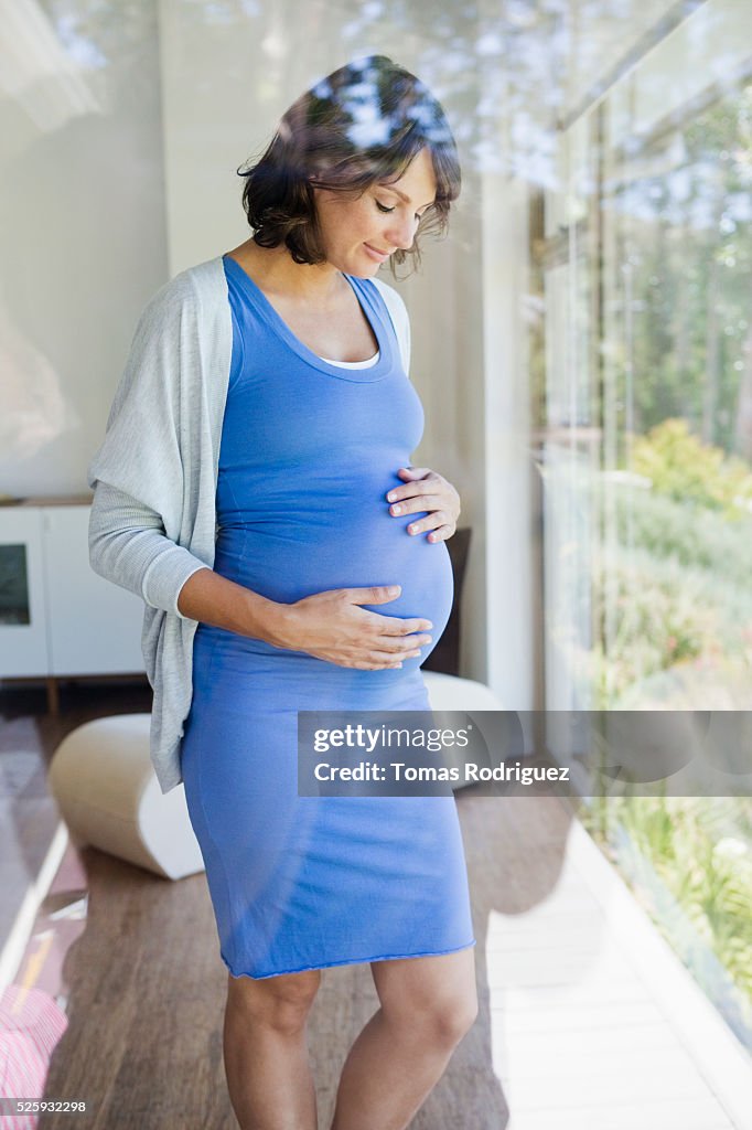 Pregnant woman standing by window