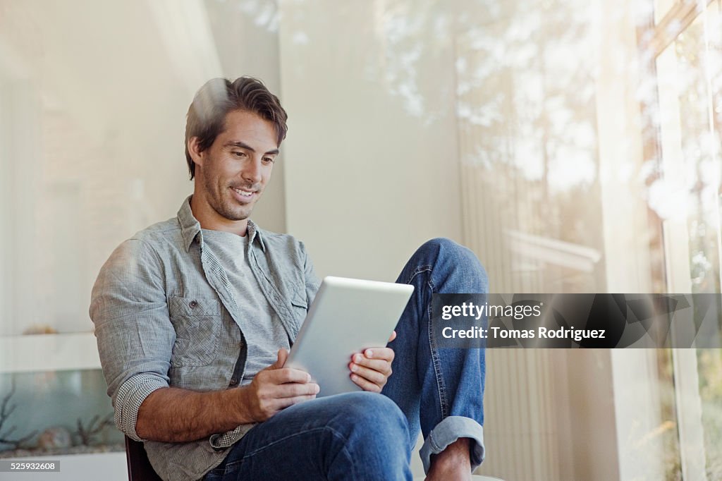 Man using tablet pc at home