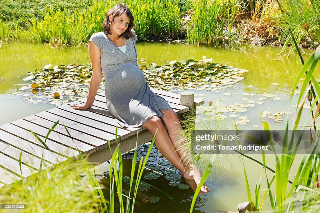 Pregnant woman sitting on jetty