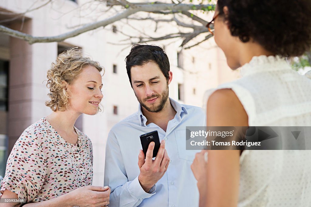 Man showing cell phone to women