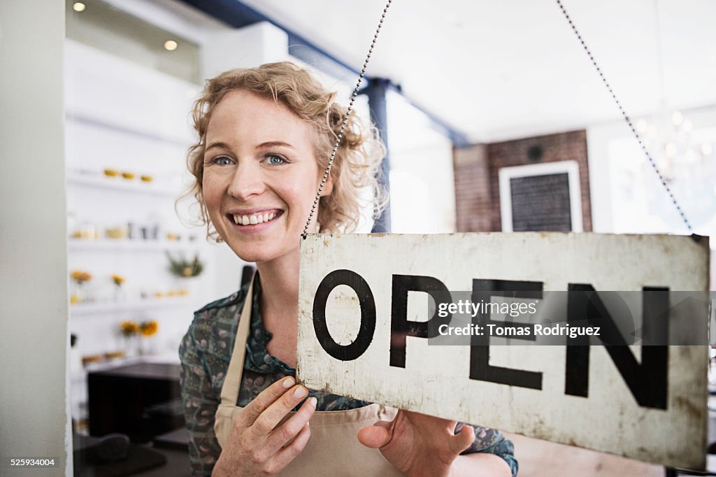 Portrait of business owner with open sign