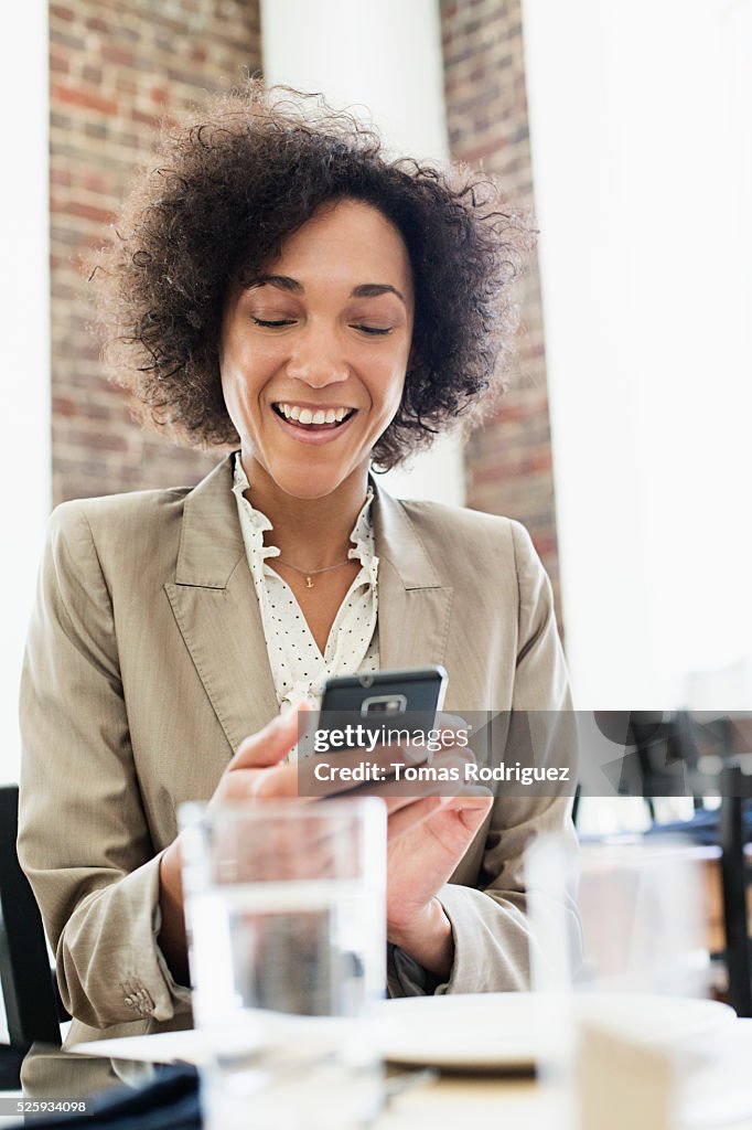 Businesswoman using smartphone in restaurant