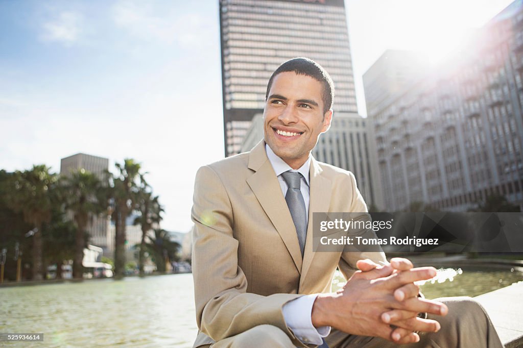 Mid adult man sitting by fountain