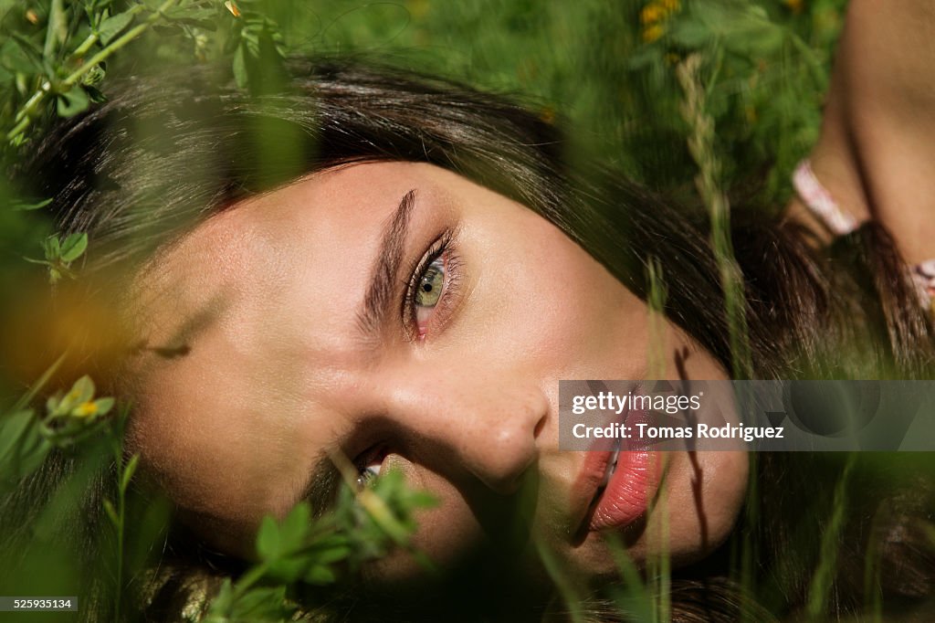 Portrait of young woman lying on grass