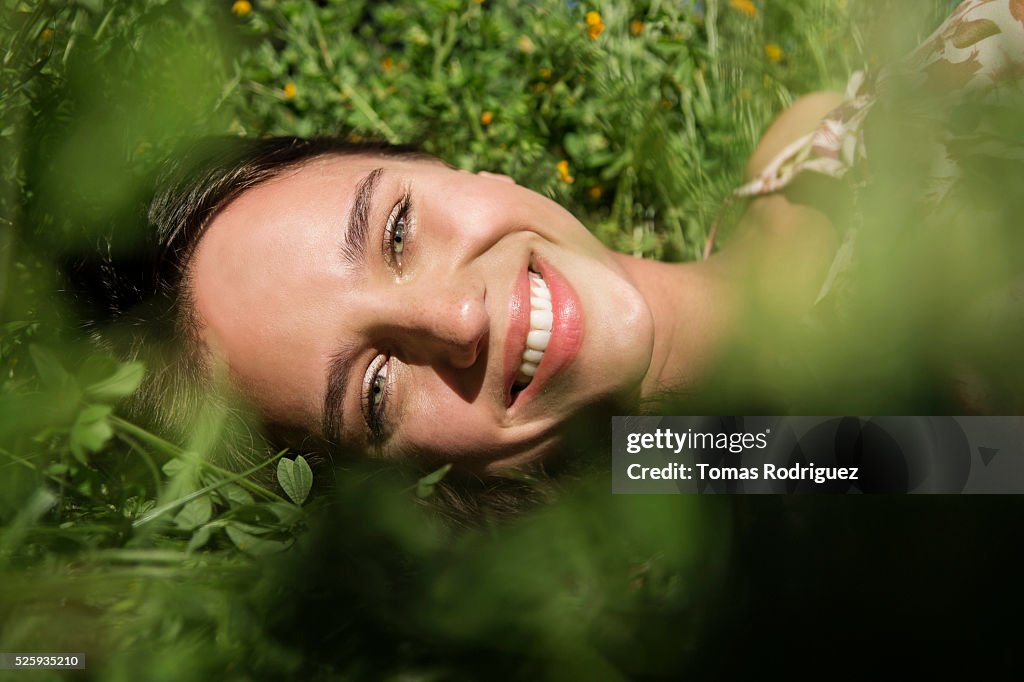 Portrait of young woman lying on grass