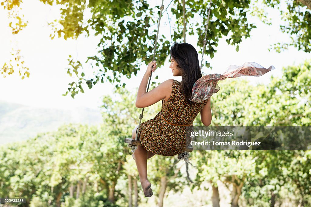 Back view of young woman on swing