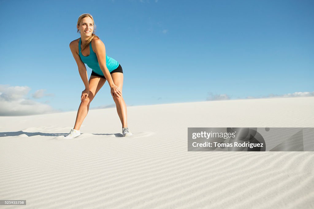 View of, young adult woman standing on sand in sports clothing