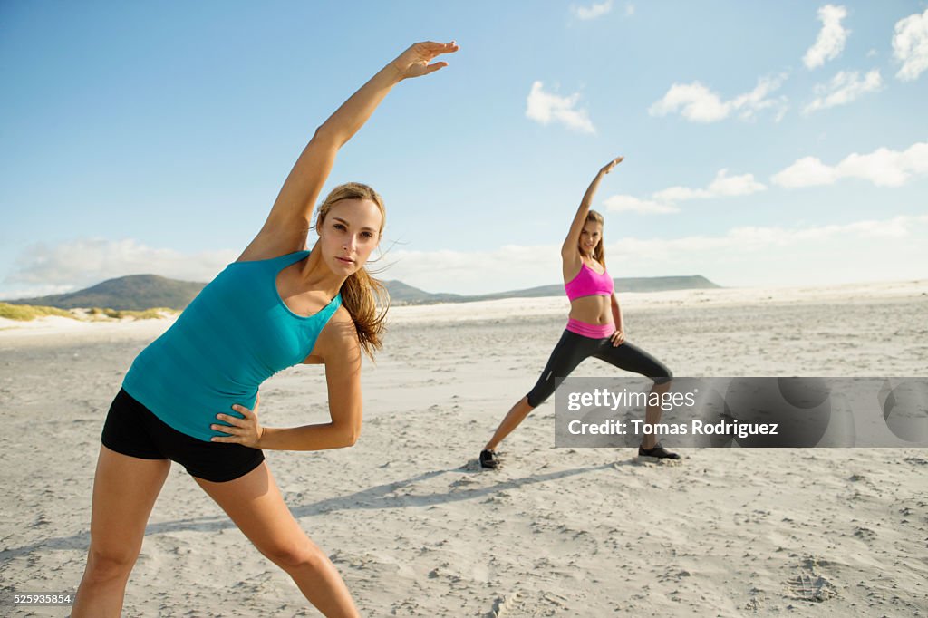 View of two young adult women, stretching arms