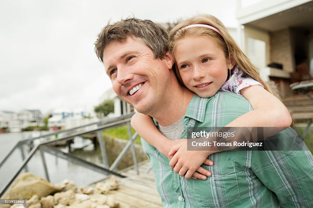 Portrait of father giving daughter (8-9) piggyback ride