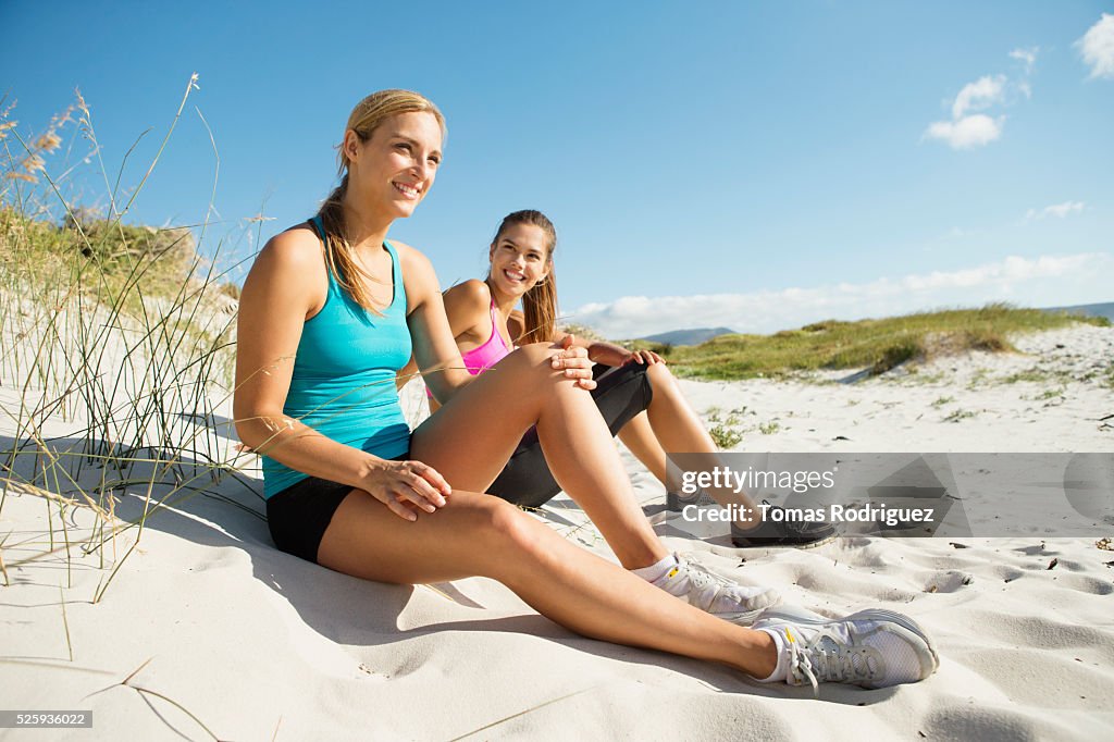 View of two young adult women sitting on dune