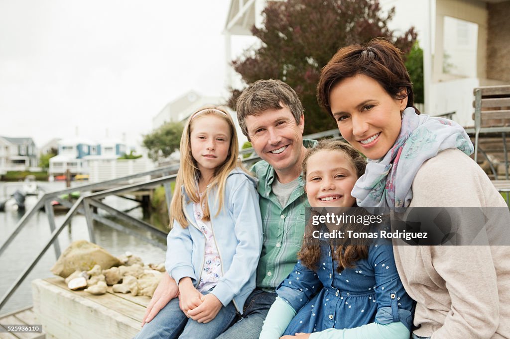 Portrait of family with two girls (6-7), (8-9) relaxing by water