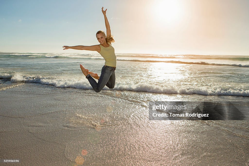 Portrait of,, young adult woman jumping on beach