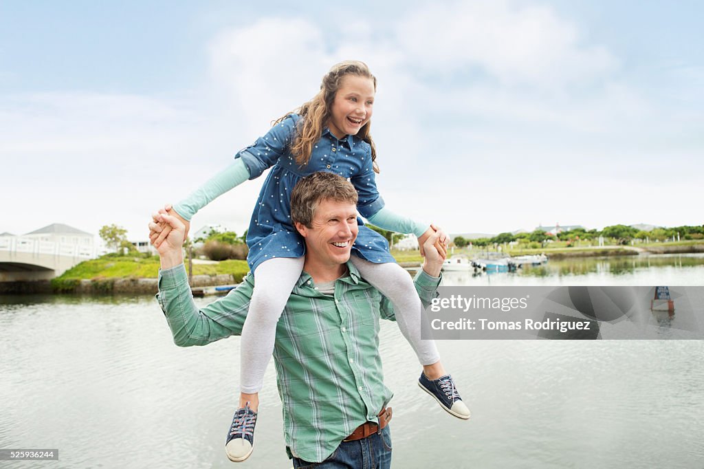 Portrait of father giving daughter (6-7) piggyback ride
