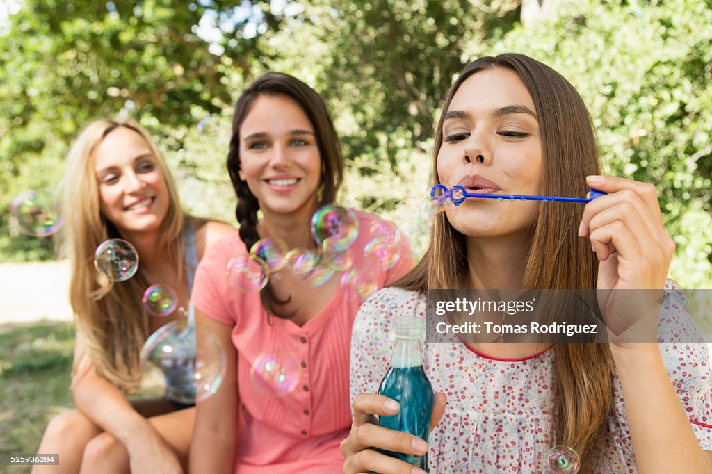 View of young women, blowing soap bubbles