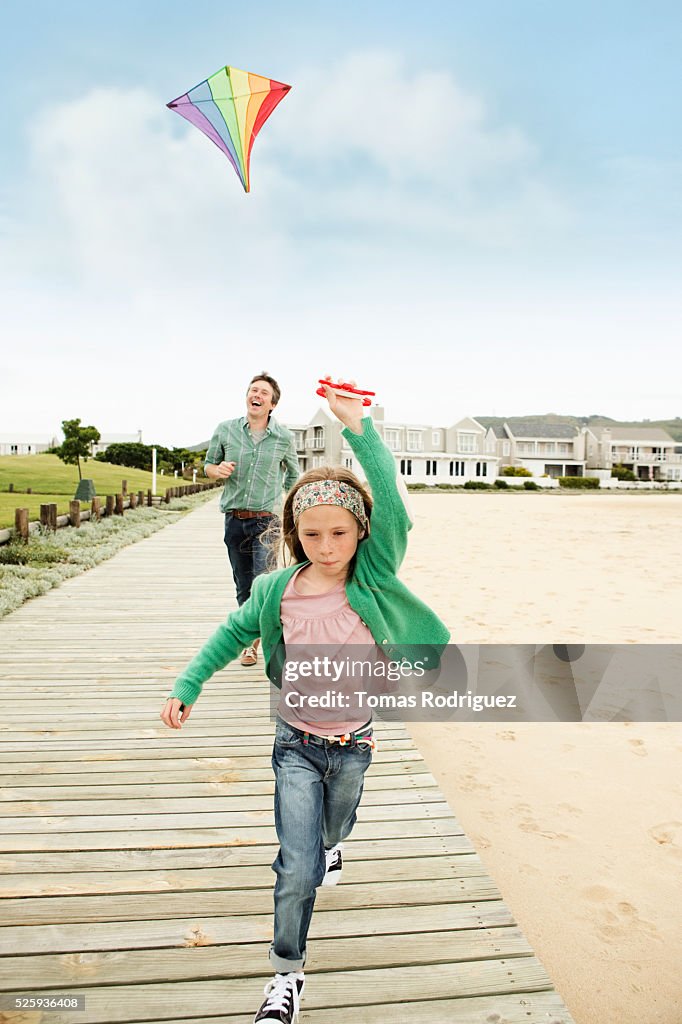 Father and daughter (8-9) flying kite