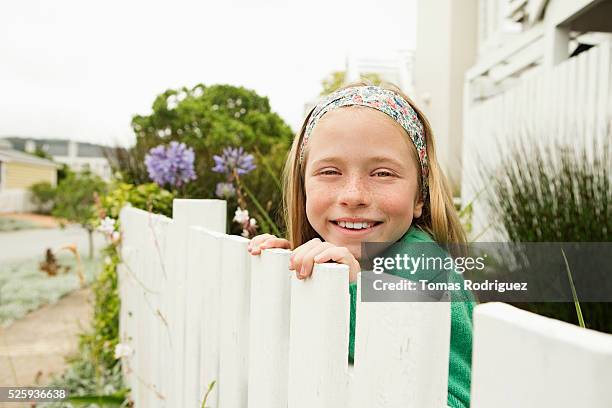 girl(8-9) hiding behind fence - girl hiding behind bush stock pictures, royalty-free photos & images