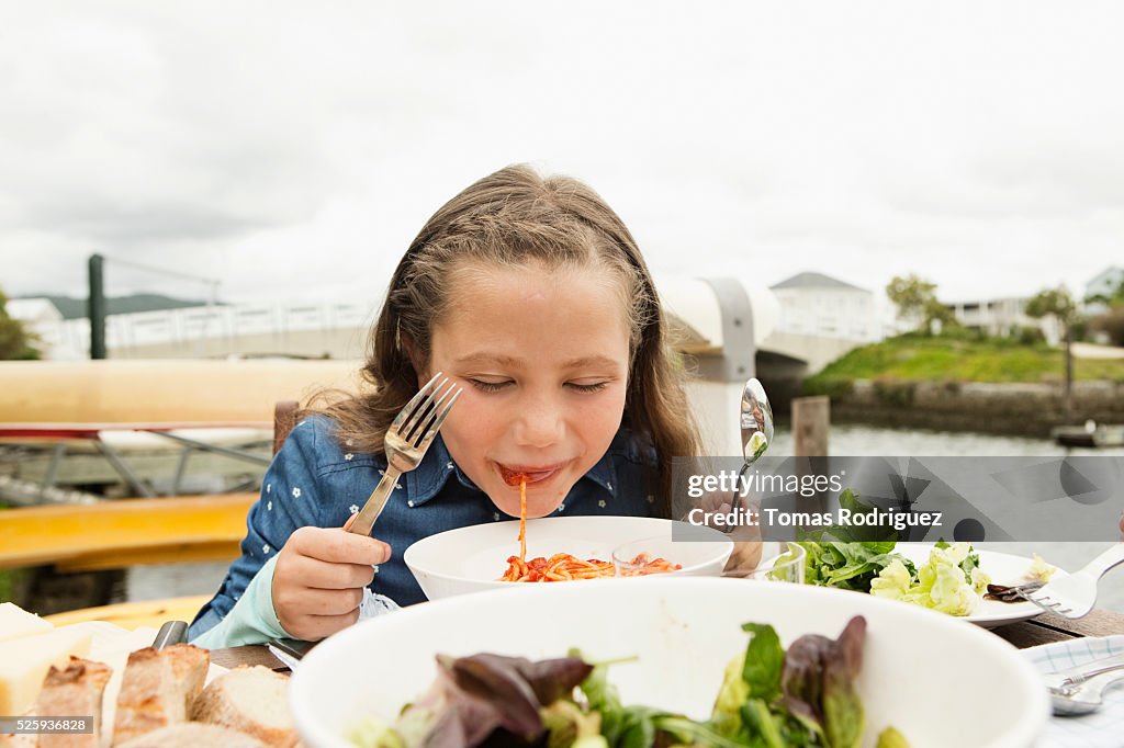 Portrait of girl (6-7) eating pasta