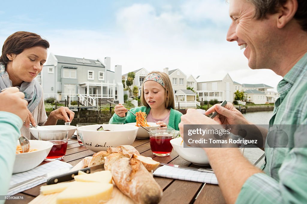 Portrait of parents and girls (6-7), (8-9) eating outdoors