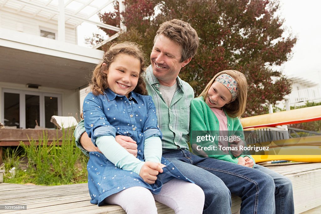 Portrait of father relaxing with daughters (6-7), (8-9)