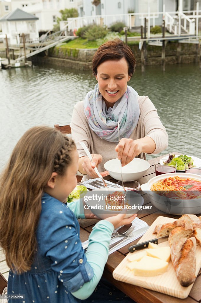 Portrait of mother and girl (6-7) eating outdoors