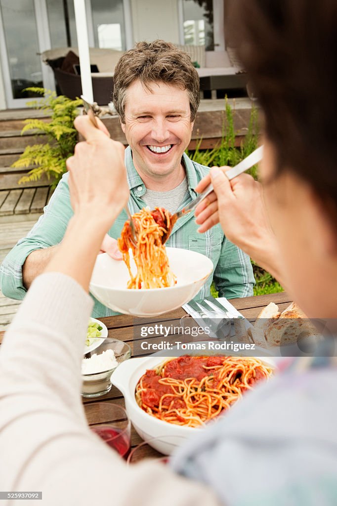 Woman serving spaghetti to man