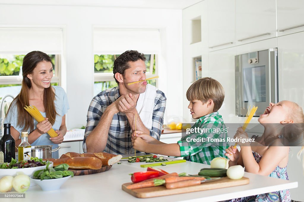 Family with two children (4-5 ,6-7) playing in kitchen