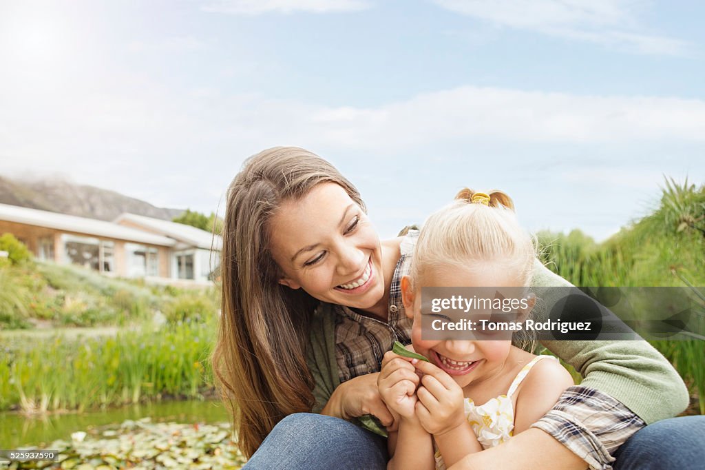 Mother embracing daughter (4-5) outdoors