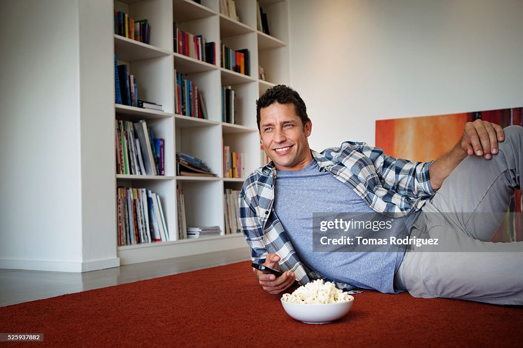 Man lying on floor and watching tv