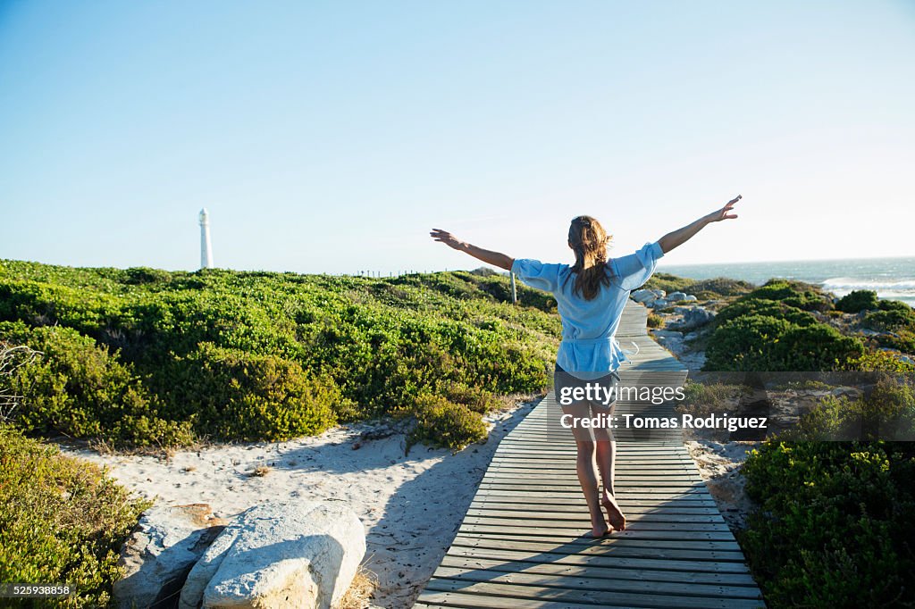 Young woman walking on boardwalk