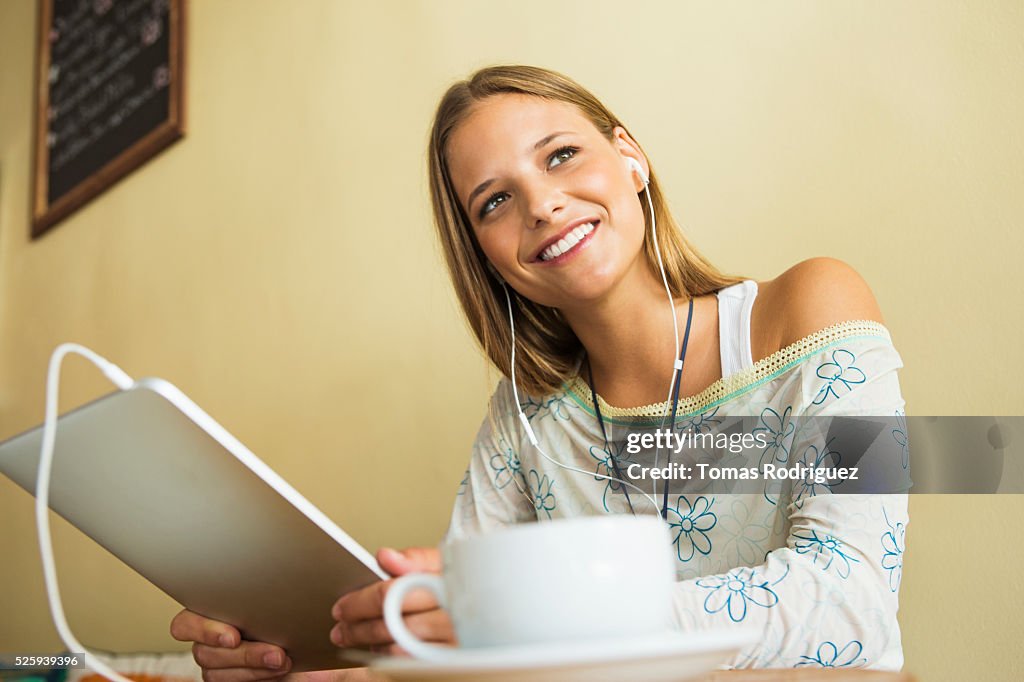 Woman using digital tablet in cafe