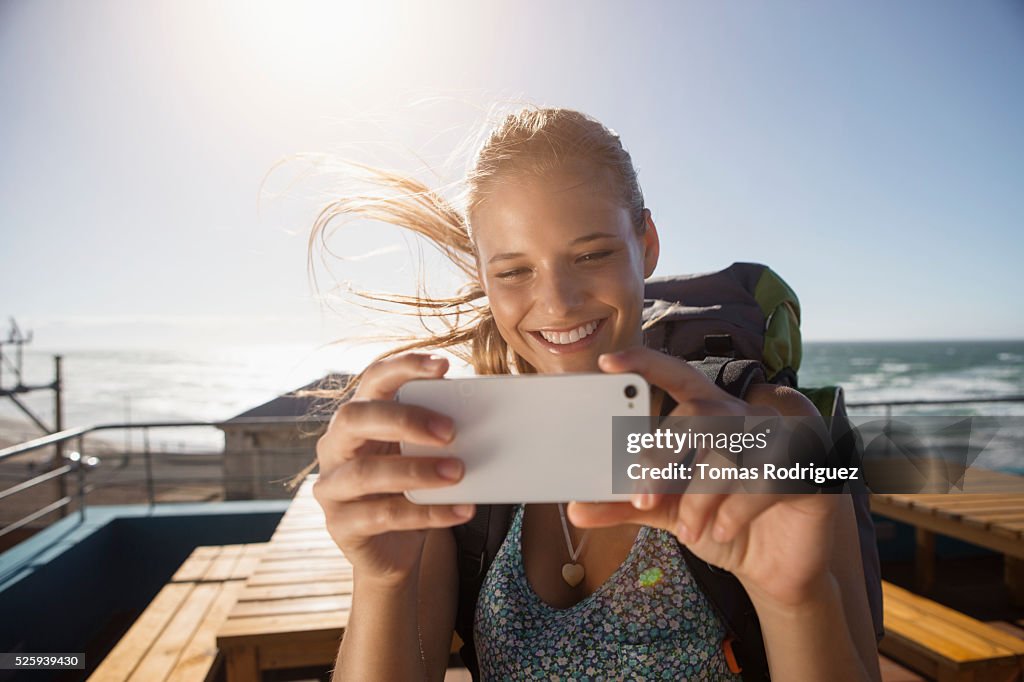 Portrait of young woman with backpack and smartphone