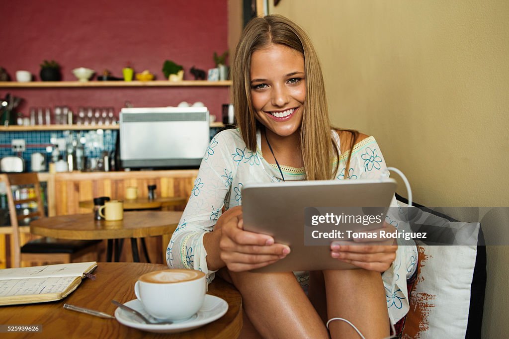 Woman using digital tablet in cafe