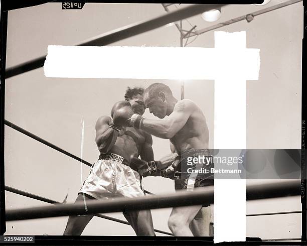 Los Angeles,CA- Sugar Ray Robinson catches Carl "Bobo" Olson below the belt in the fourth round of their scheduled 15-round middle-weight...