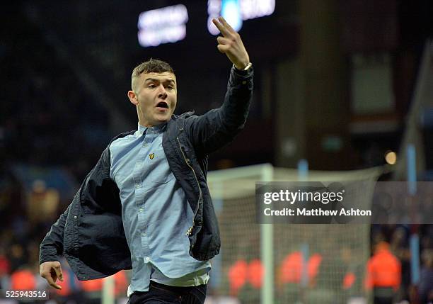 A Aston Villa fan runs onto the pitch during the match to stick two fingers up to the corralled West Bromwich Albion Fans who were protected by a...