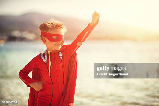kleine super held am strand - super heroe stock-fotos und bilder