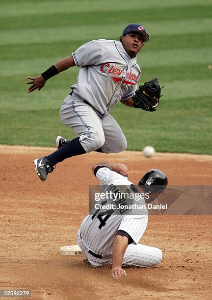 Second baseman Ronnie Belliard of the Cleveland Indians leaps over Paul Konerko of the Chicago White Sox while turning a double play on April 6, 2005...