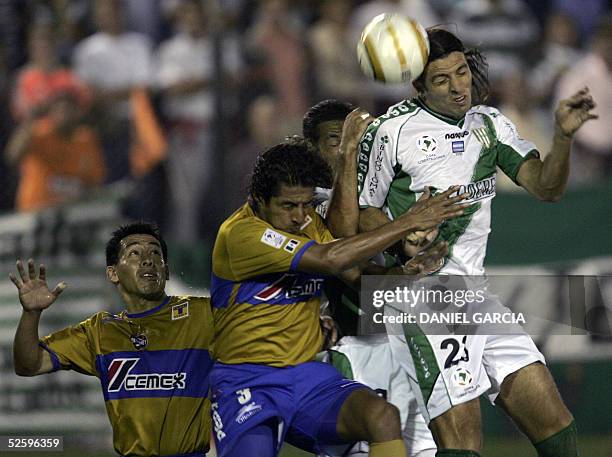 Banfield's Daniel Bilos and Tigres UANL's Omar Briseno and Sidney Banderas vie for the ball 06 April 2005 during their Libertadores Cup Group 6...