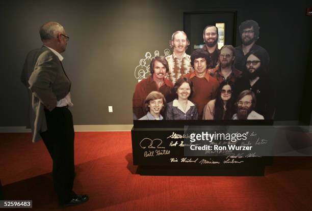 Visitor looks at a display cut-out of Microsoft's eleven employees in 1978, featuring a young Bill Gates , and Paul Allen , on display at the...
