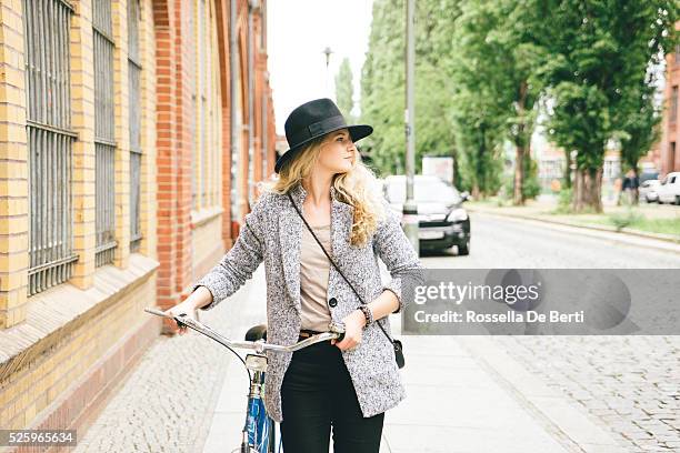 trendy young woman with her bike, city street on background - first sunny spring day in berlin stock pictures, royalty-free photos & images