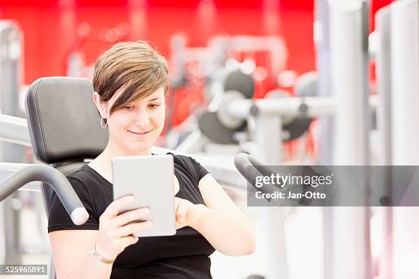 she his checking her trainingsplan on a tablet pc - adipositas stock pictures, royalty-free photos & images