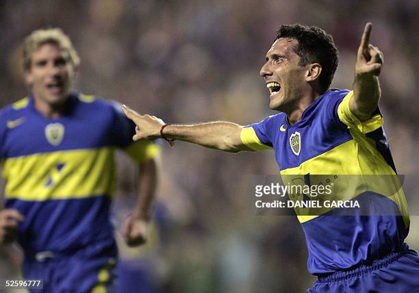 Boca Juniors' Diego Cagna celebrates after scoring the first goal against Pachuca, followed by teammate Martin Palermo 06 April 2005 during their...