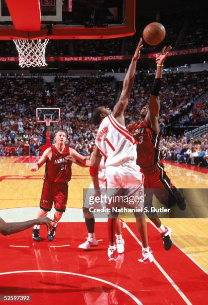 Dwyane Wade of the Miami Heat shoots over Tracy McGrady of the Houston Rockets during a game at Toyota Center on March 22, 2005 in Houston, Texas....